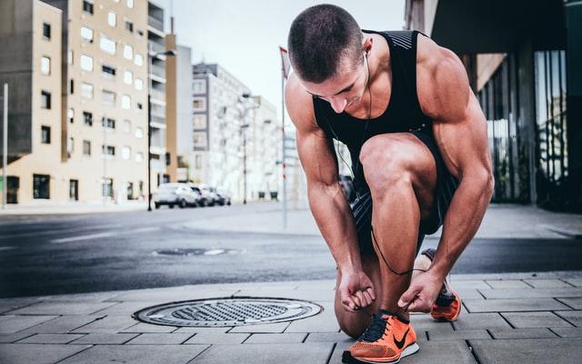 athletic man tying shoestrings on his sneakers