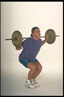 man performing squats with barbell