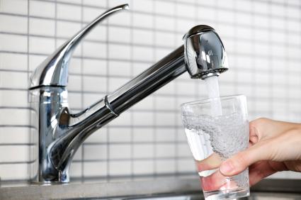 glass of water and water faucet