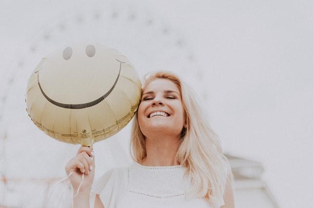 smiling woman holding a balloon