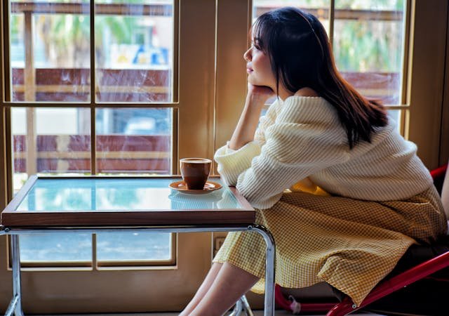 woman enjoys coffee in cozy indoor setting